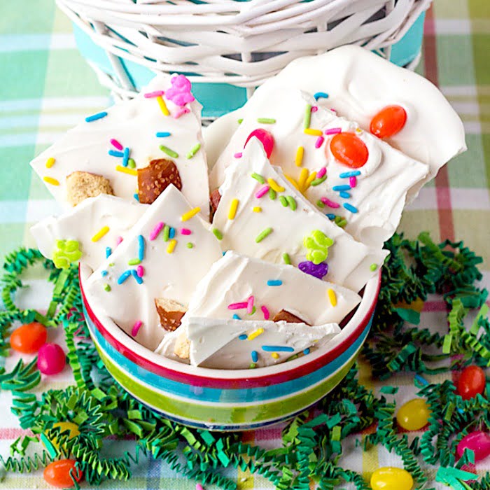 a bowl of white chocolate homemade Easter treats - bark covered with broken Dutch pretzels, pastel colored sprinkles and jelly beans