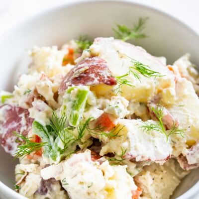 a close up view of farmers market potato salad in a white bowl