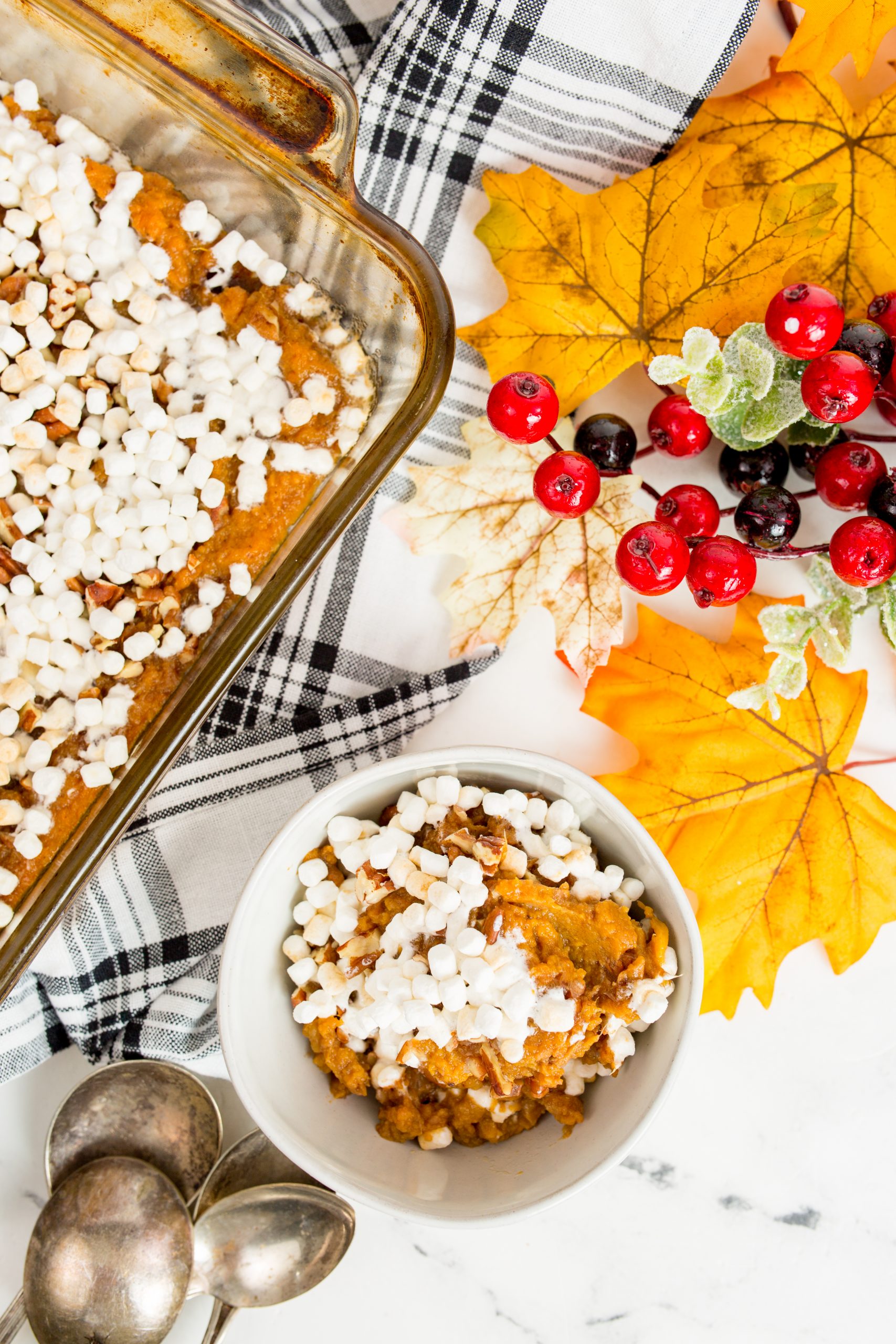 Overhead shot of sweet potato casserole with bowl and fall leaves